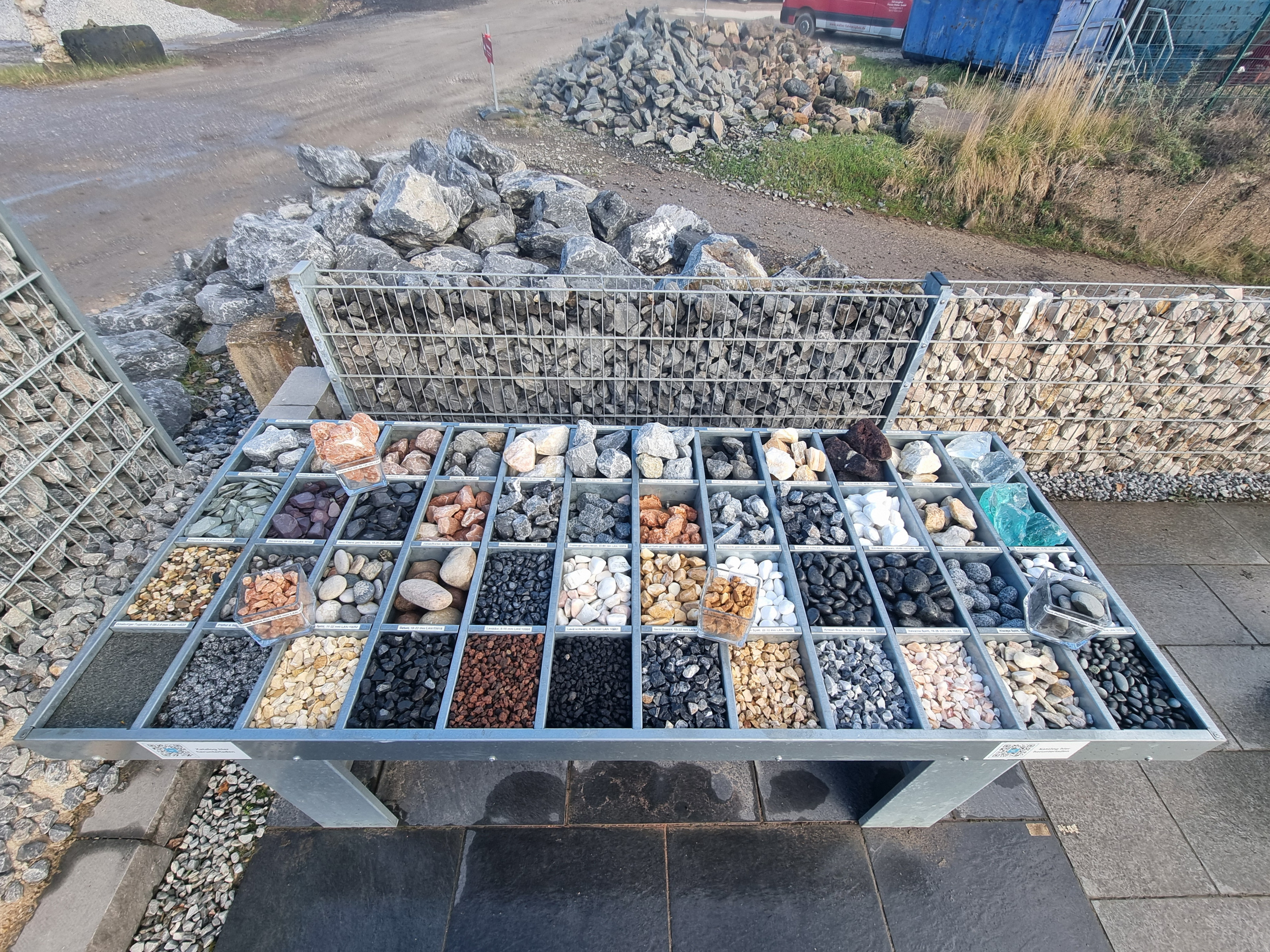 Ein Metalltisch zeigt viele Steinsorten in verschiedenen Farben und Formen sortiert