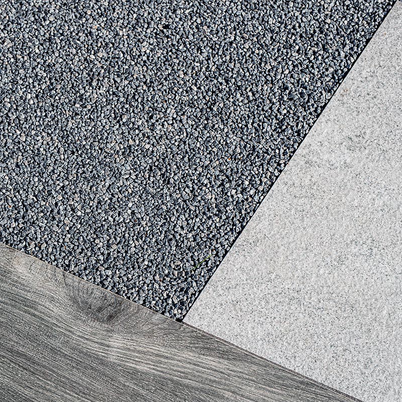 Grauer Kiesbelag trifft auf helle Steinplatte und Holzoptik im Detail