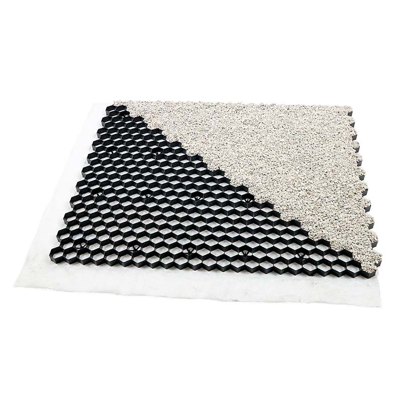 Schwarze Kunststoff Wabenmatte mit Kies gefuellt auf weissem Vlies